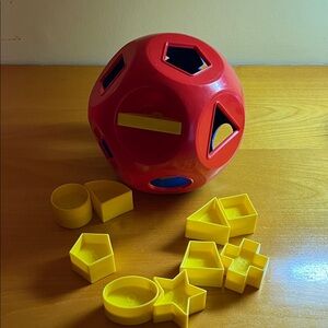Shape Sorting Ball Vintage Toy - Red and Blue with yellow, numbered pieces.